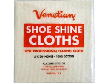 May include: A white cloth bag with a red label that says "Venetian Shoe Shine Cloths" and "One Professional Flannel Cloth 5 x 20 Inches - 100% Cotton". The label also includes the company name and address, "C.A. Zoes Mfg. Co. Chicago, Illinois 60607", and the tagline "Shoe and Leather Care Since 1905". The bag is sealed with a clear plastic zipper.