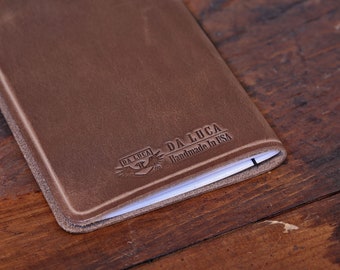 May include: A brown leather notebook cover with the text "DA LUCA Handmade in USA" embossed on the front.