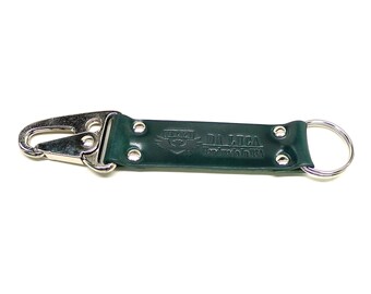 May include: A dark green leather key chain with a silver hook and a silver ring. The key chain has the text "DA LUCA Handmade in USA" embossed on it.
