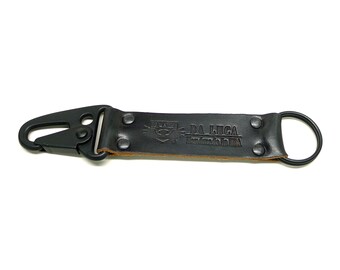 May include: Black leather key chain with a black metal clip and a ring. The leather strap has the text "DA LUCA Handmade in USA" embossed on it.