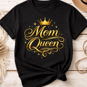 May include: Black t-shirt with a gold crown and the words "Mom Queen" in a decorative script. The design includes gold stars and flourishes, creating a regal and celebratory look. The shirt is made of a soft material.