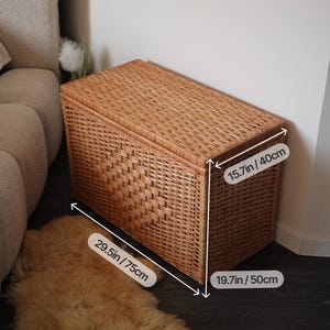Pode incluir: Um ba&uacute; retangular de vime tecido em cor castanha natural. O ba&uacute; mede 75 cm de comprimento, 50 cm de largura e 40 cm de altura. O ba&uacute; tem uma tampa e &eacute; adequado para guardar objetos. O ba&uacute; est&aacute; colocado sobre uma superf&iacute;cie escura.