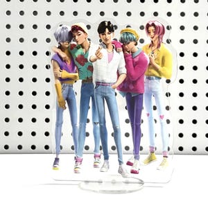 May include: A clear acrylic stand featuring a group of five stylized male figures. They are dressed in various colorful outfits, including jeans, shirts, and sweaters. The figures are posed together, with one making a heart gesture with their fingers.