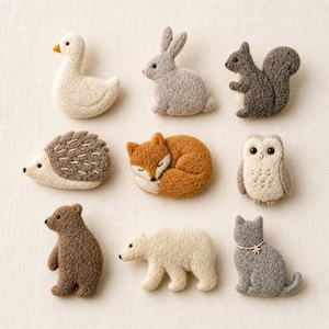 May include: A collection of nine felt animal figures, including a white goose, gray rabbit, dark gray squirrel, hedgehog, orange fox, owl, brown bear, polar bear, and gray cat. Each figure is intricately detailed and designed with a soft, textured appearance.