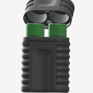 Puede incluir: Un dispositivo rectangular negro con una tapa con bisagras, que revela dos objetos cilíndricos verdes. El dispositivo tiene un exterior texturizado y acanalado. La sección superior tiene dos aberturas circulares. El fondo es blanco liso.