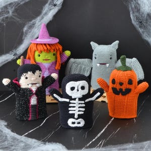 以下が含まれることがあります： ハロウィーンをテーマにした5種類の編みぐるみハンドパペット。黒いマントの吸血鬼、オレンジ色の髪と紫の帽子の魔女、灰色のコウモリ、白い骨の模様がある黒い骸骨、そして緑の茎が付いたオレンジ色のジャック・オー・ランタンが揃っています。