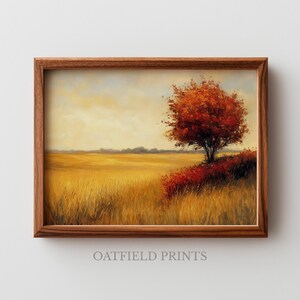 Puede incluir: Pintura de paisaje enmarcada que representa un campo de hierba dorada bajo un cielo amarillo pálido. Un árbol con hojas rojas vibrantes se alza sobre una pequeña colina, con arbustos rojos en su base. El marco es de madera marrón. El texto "OATFIELD PRINTS" está en la parte inferior.