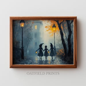 May include: A framed print depicts three figures in witch hats holding hands and lanterns, walking down a cobblestone street. The artwork is set in a misty, nighttime scene with street lamps and a building in the background. The frame is a warm brown.