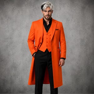 Könnte beinhalten: Ein leuchtend orangefarbener langer Mantel über einer orangefarbenen Weste und einem schwarzen Hemd mit schwarzer Hose. Der Mantel hat ein steigendes Revers, lange Ärmel und einen Knopfverschluss. Die Weste hat eine fünf-Knopf-Leiste und einen Saum.