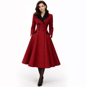Könnte beinhalten: Ein langer, roter Mantel mit schwarzem Kragen und schwarzem Besatz an den Taschen. Der Mantel hat ein doppelreihiges Design mit schwarzen Knöpfen und einem ausgestellten Rock. Der Mantel ist knielang und hat lange Ärmel.