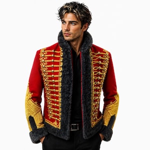 May include: A red military-style jacket with gold embellishments, buttons, and trim. The jacket features a black faux fur collar and cuffs. The sleeves have gold embroidery. The jacket is worn over a black shirt and pants.