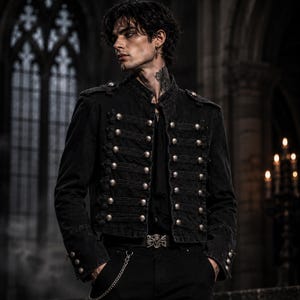 May include: A black denim military-style jacket featuring a high collar, long sleeves, and a front closure adorned with multiple rows of horizontal braided trim and round silver-toned metal buttons. The jacket includes shoulder epaulets and cuffs.