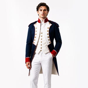 Puede incluir: Una chaqueta azul marino de estilo militar con ribetes rojos y botones dorados. La chaqueta se combina con un chaleco blanco y pantalones blancos. La chaqueta tiene un cuello alto y charreteras. El atuendo recuerda a los uniformes militares históricos.