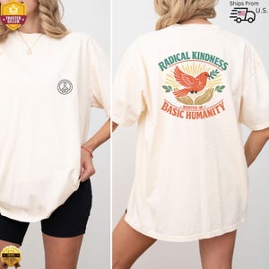May include: A cream-coloured t-shirt featuring a peace symbol on the front and a graphic on the back. The graphic reads "RADICAL KINDNESS ROOTED IN BASIC HUMANITY" with a red bird, hands, and leaves. The t-shirt has a relaxed fit.