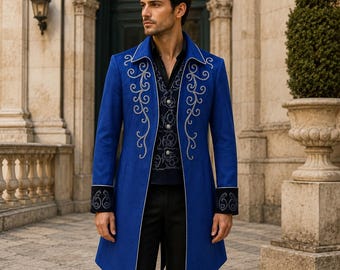Pode incluir: Um casaco comprido azul royal com bordados prateados e punhos pretos. O casaco apresenta uma gola entalhada e uma bainha assimétrica única. Parte de um traje formal com colete e camisa pretos.