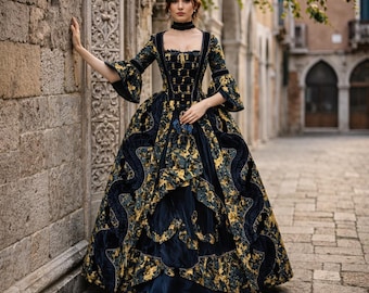 May include: A woman wearing a long, ornate gown with a square neckline and bell sleeves. The dress features a dark blue velvet fabric with gold floral patterns and trim. The gown has a full skirt and is accessorized with a black choker.