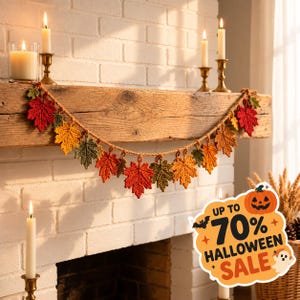 May include: A crochet garland featuring a series of interconnected autumn leaves in shades of red, orange, yellow, and green, suspended from a thick twine string. The leaves are textured with visible stitching and are arranged in a decorative drape.