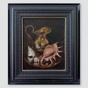 Può includere: Un dipinto a olio in una cornice nera raffigurante una brocca metallica e tre conchiglie disposte su un vassoio circolare su uno sfondo scuro. La brocca ha un riflesso dorato, mentre le conchiglie mostrano sfumature di rosa, bianco e marrone chiaro.