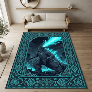 May include: A rectangular area rug featuring a dark gray monster breathing a bright cyan flame. The central illustration is framed by a geometric border in shades of teal and dark blue, with intricate repeating patterns surrounding the creature.