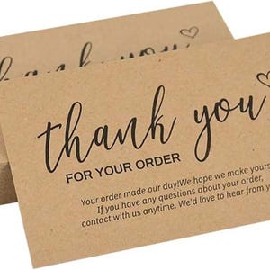 May include: Kraft paper thank you cards with black script text. The cards say "thank you" and "for your order" with a small heart symbol. A stack of cards is visible.