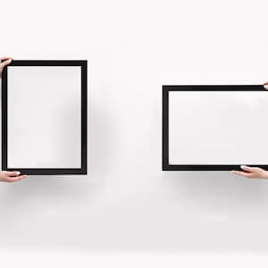 May include: Two rectangular picture frames with thin black borders. One frame is oriented vertically, and the other frame is oriented horizontally. Both frames feature a plain white interior surface, providing a clean and neutral display area.
