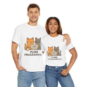 May include: White t-shirts with a cartoon design of two cats, one orange and one grey, working on a laptop. The text "PURR PROGRAMMING" is printed below the cats. The shirts are worn by two people.