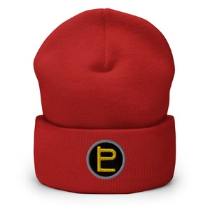 May include: Red knitted beanie with a black and grey circle with a gold letter "P" embroidered on the front.