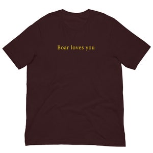 May include: A maroon short-sleeved t-shirt with the text "Boar loves you" printed in yellow.