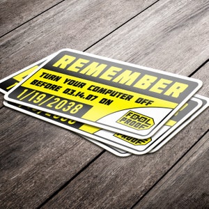 May include: A yellow and black warning sign with the text "REMEMBER TURN YOUR COMPUTER OFF BEFORE 03.14.07 ON 1/19/2038" and a black and white "FOOL PROOF" logo.
