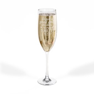 Könnte beinhalten: Ein Champagnerglas gefüllt mit einer sprudelnden, goldenen Flüssigkeit. Das Glas hat einen langen Stiel und eine breite Schale. Auf dem Glas steht der Text: "I'm just a good girl who loves to read SMUT."