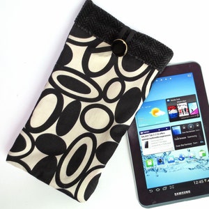 May include: A black and white patterned fabric phone case with a black and gray tablet inside. The tablet screen shows a blue background with the Samsung logo and the time 12:45.