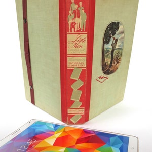 Könnte beinhalten: Ein Vintage-Hardcover-Buch mit rotem Rücken und grünem Einband. Das Buch trägt den Titel "Little Men" von Louisa May Alcott. Der Umschlag zeigt eine Illustration einer Gruppe von Jungen und eine Szene mit einem Mann, der Holz hackt.