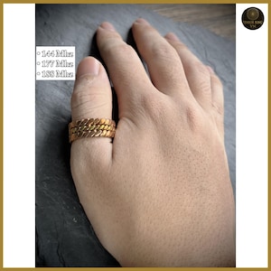 May include: A gold-colored ring with a textured, braided design is worn on a person's thumb. The ring is made of three bands. Text on the left side of the image reads "144 Mhz", "177 Mhz", and "188 Mhz". The Tensor Ring VN logo is in the upper right corner.