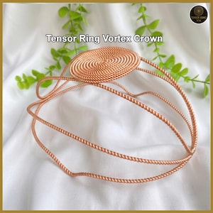 May include: A copper-colored Tensor Ring Vortex Crown. The crown features a central, circular design with a spiral pattern, connected to the headband by three curved bands. The text "Tensor Ring Vortex Crown" is displayed above the crown.