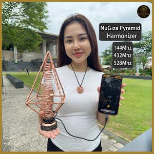 Op de afbeelding: Een koperkleurige NuGiza Pyramid Harmonizer met een spiraalvormige spoel en een zwarte basis. De afbeelding toont ook een smartphone met een golfvorm en de tekst "NuGiza Pyramid Harmonizer", "144Mhz", "432Mhz" en "528Mhz".