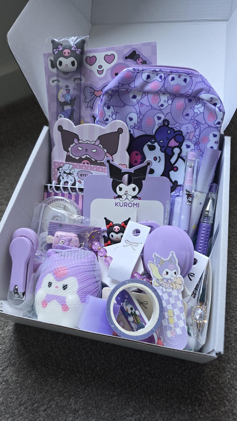 May include: A white box filled with purple Kuromi-themed stationery and accessories. Items include a pencil case, stickers, pens, a ruler, washi tape, and a nail clipper. The box is open, revealing the contents inside.