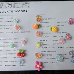 May include: A framed display featuring various small, colorful accessories. The items include keychains, squishies, and hair clips, along with other stationery and novelty items. The text "DELICATE SCOOPS" is at the top.