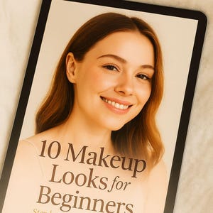 Könnte beinhalten: Ein digitales Tablet zeigt eine lächelnde Frau mit rotbraunem Haar. Der Bildschirm zeigt den Text "10 Makeup Looks for Beginners" und "Step by Step Illustrated Guide". Das Bild ist vor einem neutralen Hintergrund platziert.