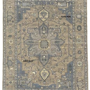 Puede incluir: Una alfombra rectangular con un diseño intrincado y simétrico. La alfombra presenta un medallón central y un borde en tonos azules, beige y crema. El texto "SOHO RUG" es visible en varios lugares de la alfombra.
