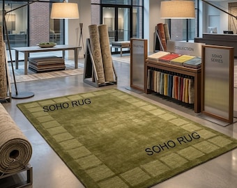 Tappeto in lana trapuntato a mano, colore verde oliva, con bordo a griglia in stile moderno.