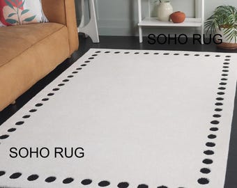 Dywan wełniany Soho tkany ręcznie - minimalistyczny dywan w białe i czarne kropki na bordiurze.