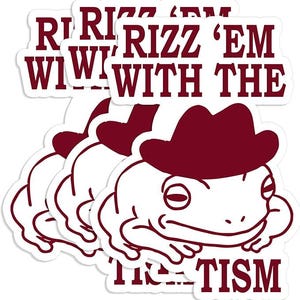 May include: A stack of white stickers featuring a cartoon frog wearing a maroon cowboy hat. The stickers have maroon text that reads "Rizz 'em with the Tism". The frog has a relaxed expression.