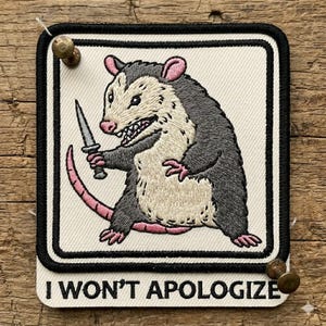 May include: A set of three ceramic mugs with a speckled, matte finish. The mugs are in shades of cream, light gray, and dark gray. Each mug has a simple, minimalist design and a rounded handle. The mugs are likely for coffee or tea.