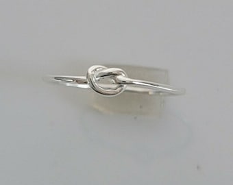 May include: A silver knot ring with a simple design.