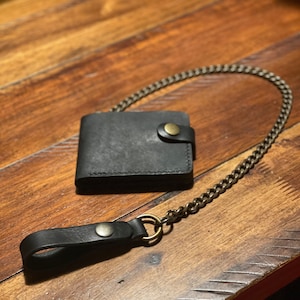 Cartera de piel con cadena plegable y cierre a presión