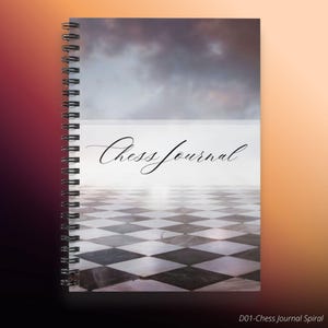 May include: Spiral-bound journal with a cover featuring a chess board design. The cover has the words "Chess Journal" in elegant script. The background shows a cloudy sky over the chess board.