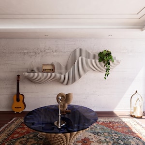 Könnte beinhalten: Ein modernes Wohnzimmer mit einem einzigartigen, wellenförmigen Holzregal mit Radio und Pflanze. Ein runder blauer Tisch mit Spiralfuß steht auf einem gemusterten Teppich. Eine Gitarre lehnt an der Wand, und rechts steht eine Kerzenlaterne.