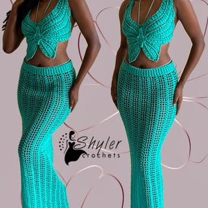 Puede incluir: Conjunto de dos piezas de ganchillo turquesa, con un top en forma de mariposa y una falda larga a juego. El top tiene un diseño de cuello halter. La falda es ajustada, de tejido abierto. El conjunto está hecho a mano. La marca "Shyler Crochets" es visible.