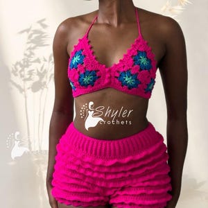Peut inclure: Ensemble bikini crochet rose vif. Le haut de bikini, de style halter, présente des motifs floraux bleus et verts. Le short est à volants. Fait main.