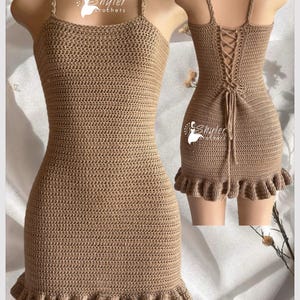 Può includere: Un abito all'uncinetto color beige con spalline sottili e orlo a balze. L'abito ha un corpetto aderente e un dettaglio con lacci sulla schiena. L'abito è esposto su un manichino. Il marchio "Shyler Crochets" è visibile.